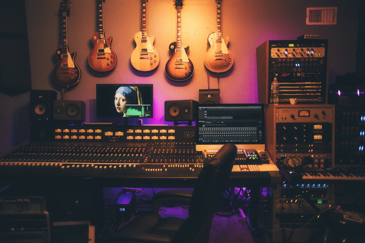 A recording room with audio equipment and guitars