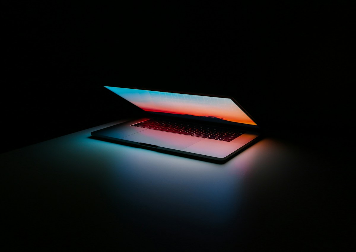 Open laptop illuminated against a dark background